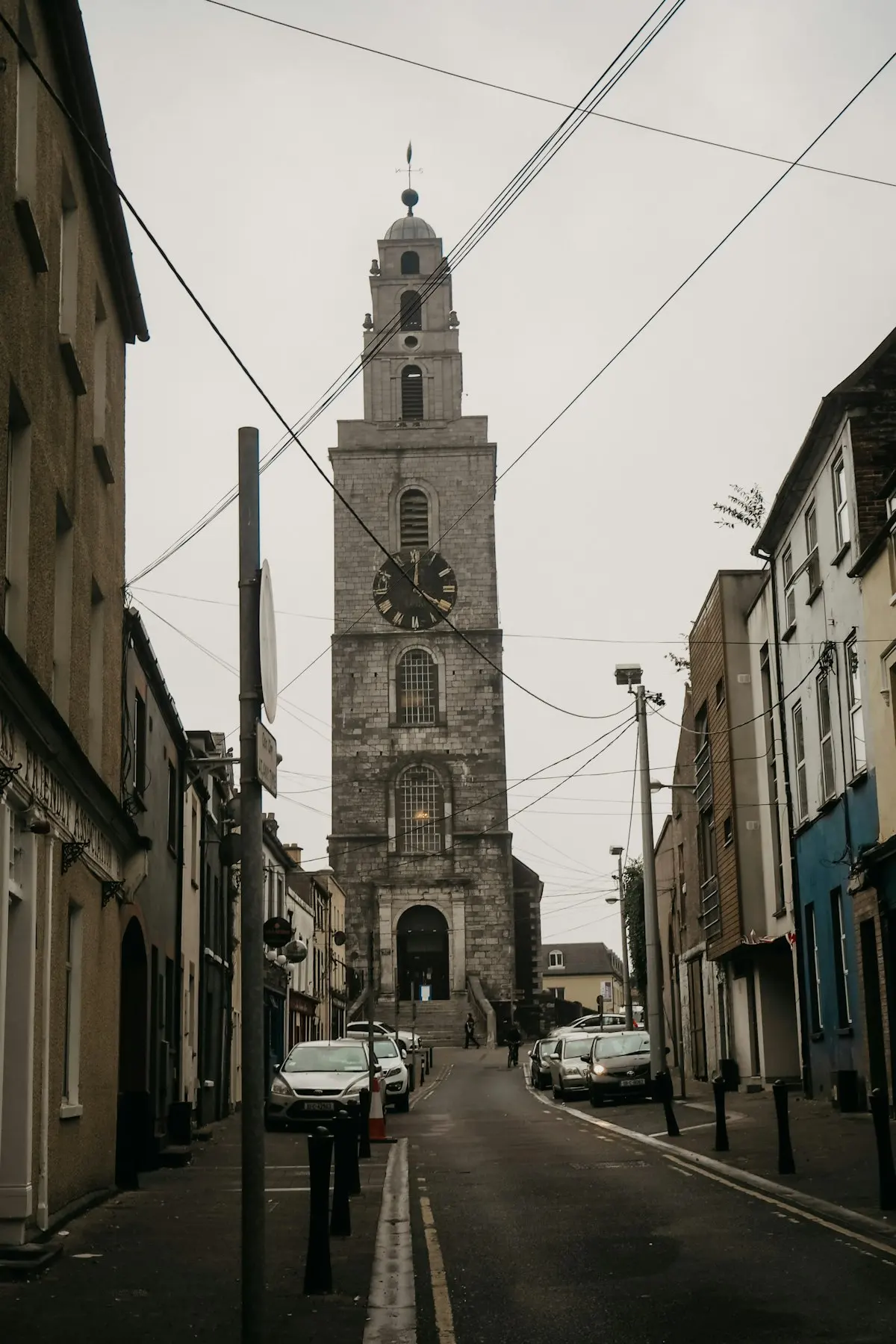 Cars parked on a street below Shandon bell tower in Cork city